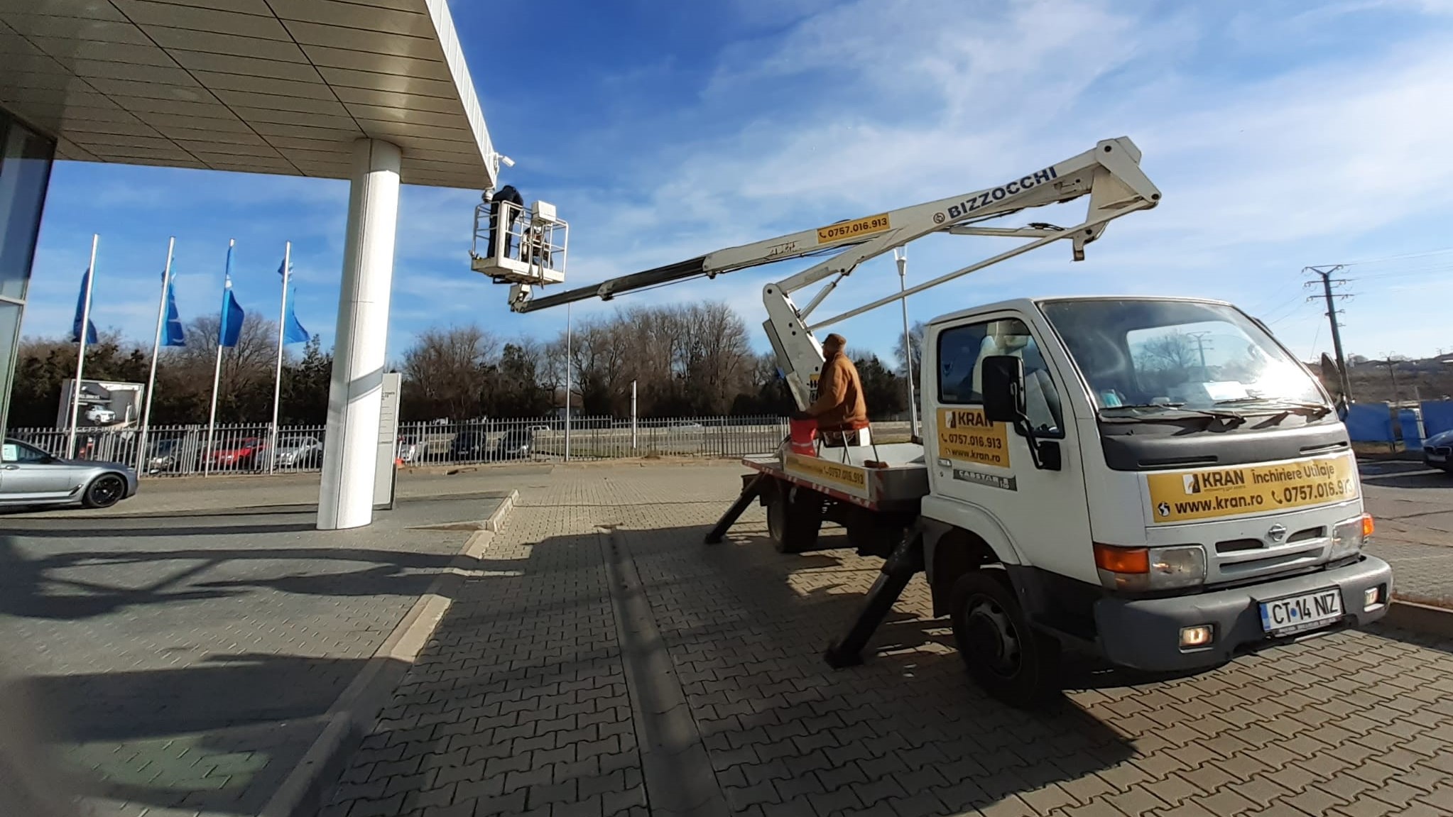 three person doing surveillance camera installation with white truck mounted boom lift