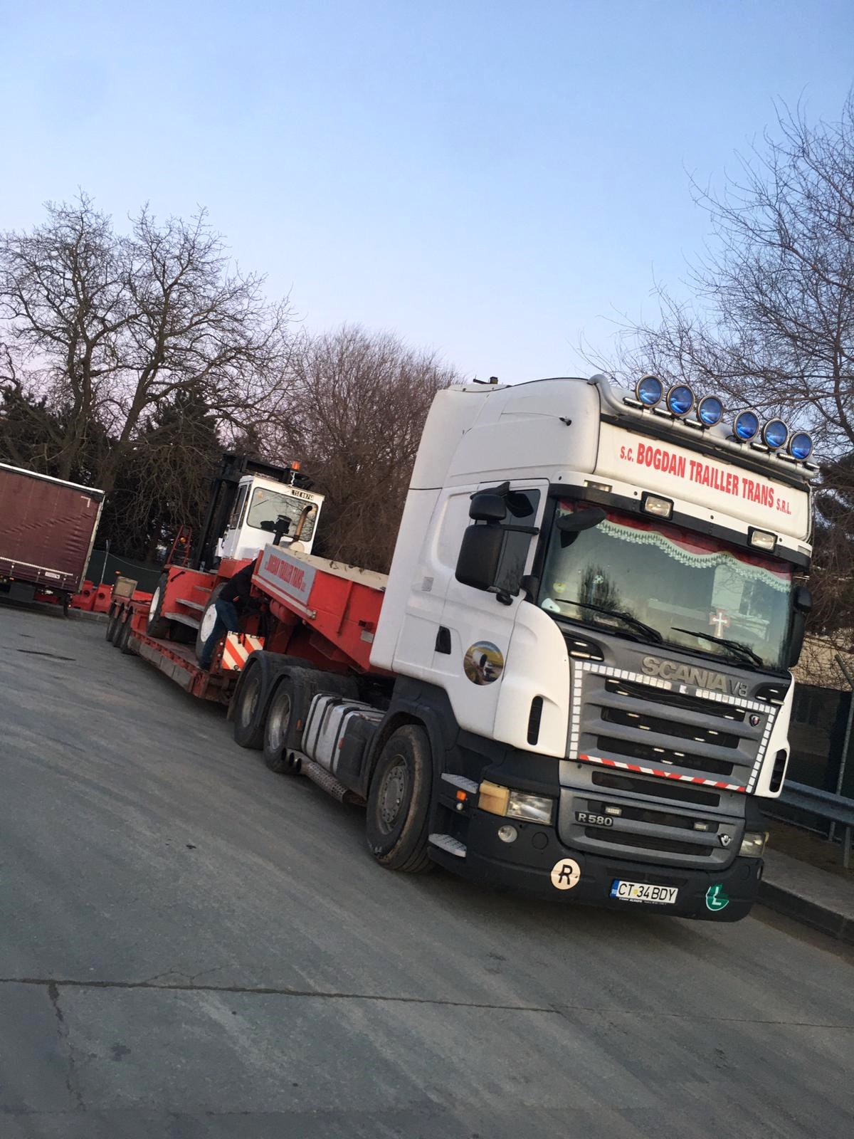 lifting freight container using large industrial forklift