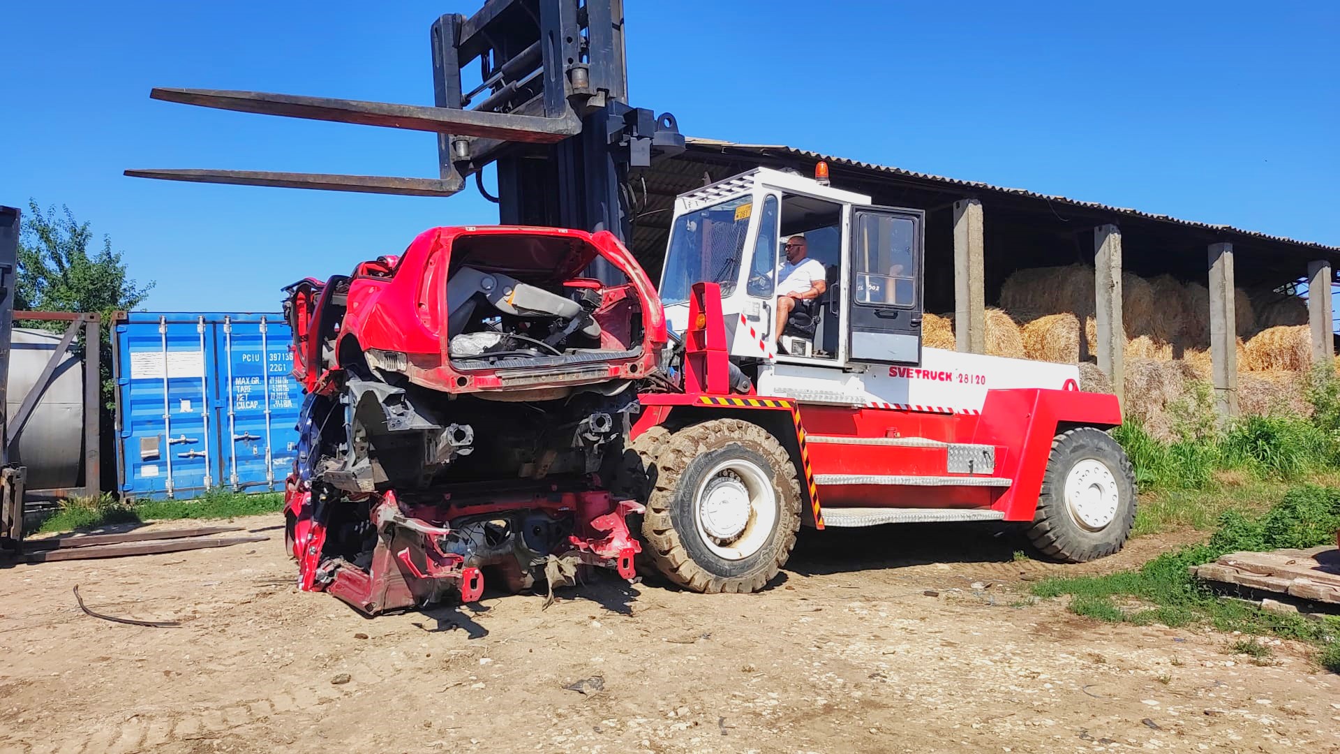 Heavy-duty forklift rental- Manipulating metal waste at a car desmantling park